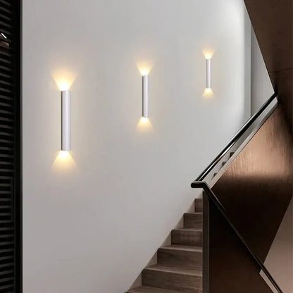 Modern black and silver led wall lamp with sleek cylindrical bodies providing warm up and down light sources