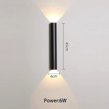 Modern black and silver led wall lamp with cylindrical design and two warm white downward beams for bedroom or tv background