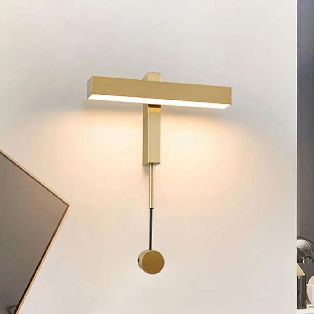 Gold-toned modern wall lamp with adjustable arm bulb base and rectangular light bar featuring a circular pull-down switch