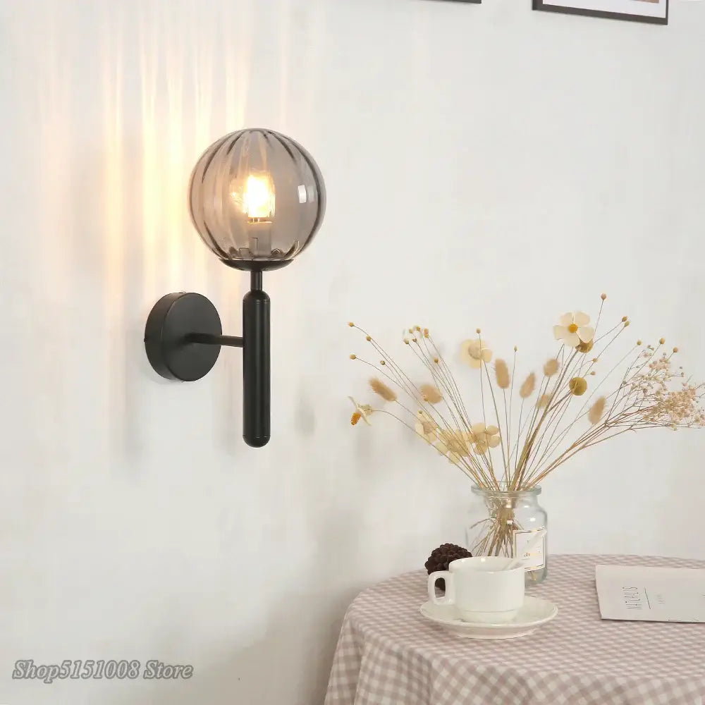 Modern black wall lamp with a decorbites glass ball led and textured smoked glass globe for bedroom sconce lighting