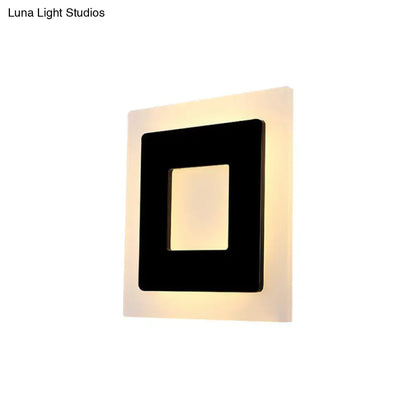 Modern black square sconce light with a sleek frame providing warm light for bedroom illumination
