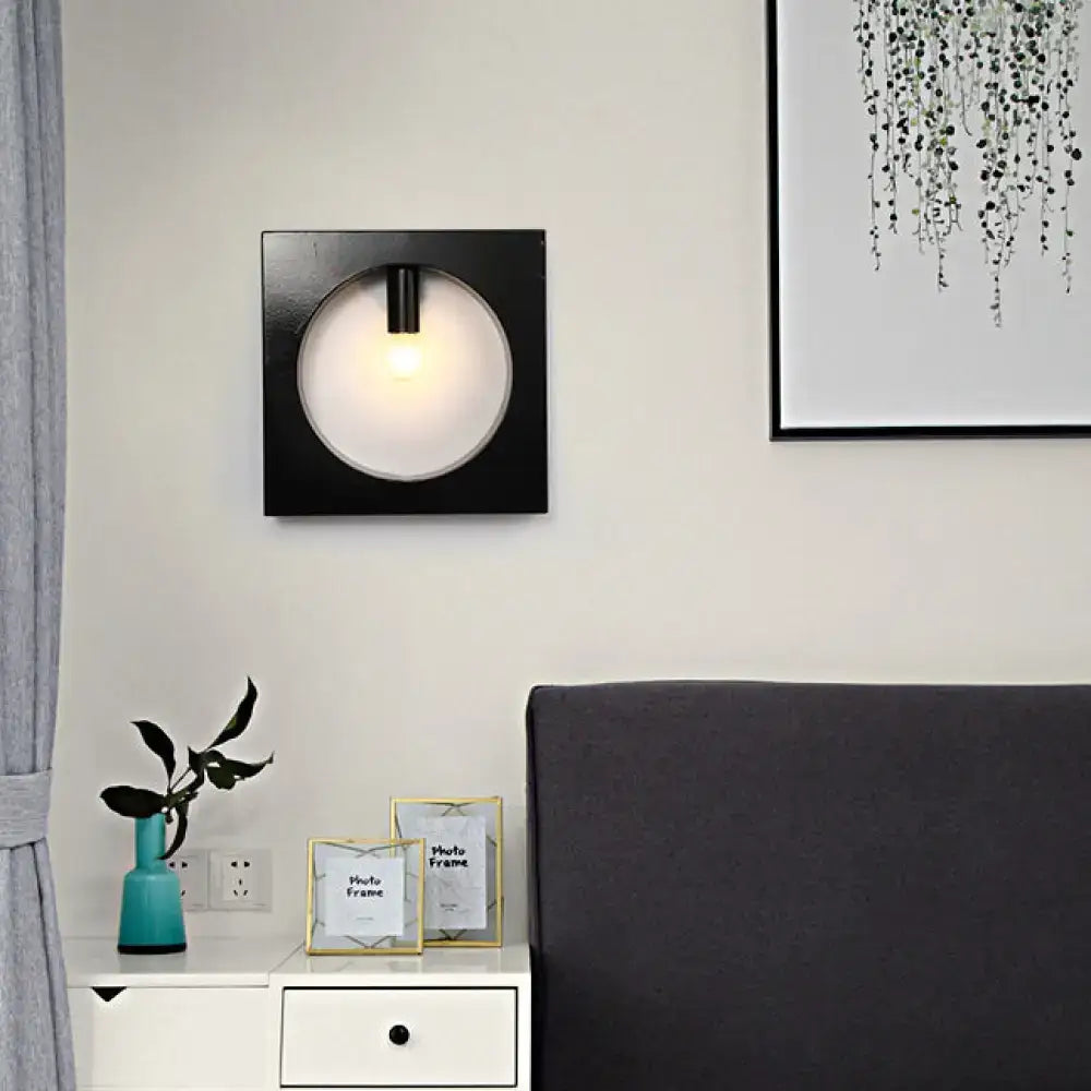 Modern black square wall sconce lamp with circular frosted glass diffuser and central light bulb for bathroom use