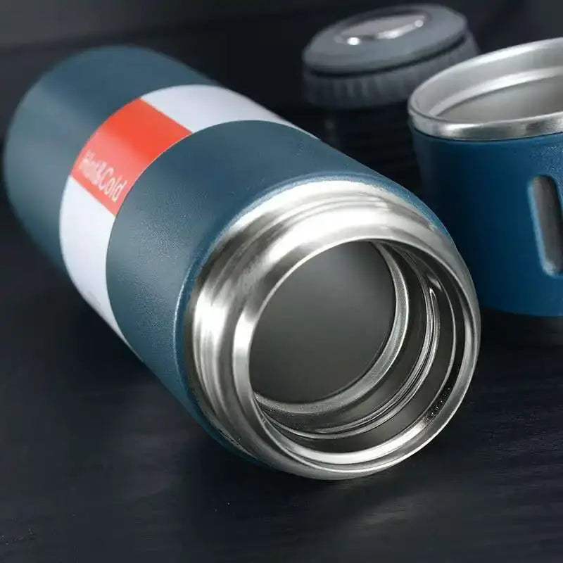Teal insulated travel mug with stainless steel rim and orange white label in modern black stainless steel insulated water bottle gift set