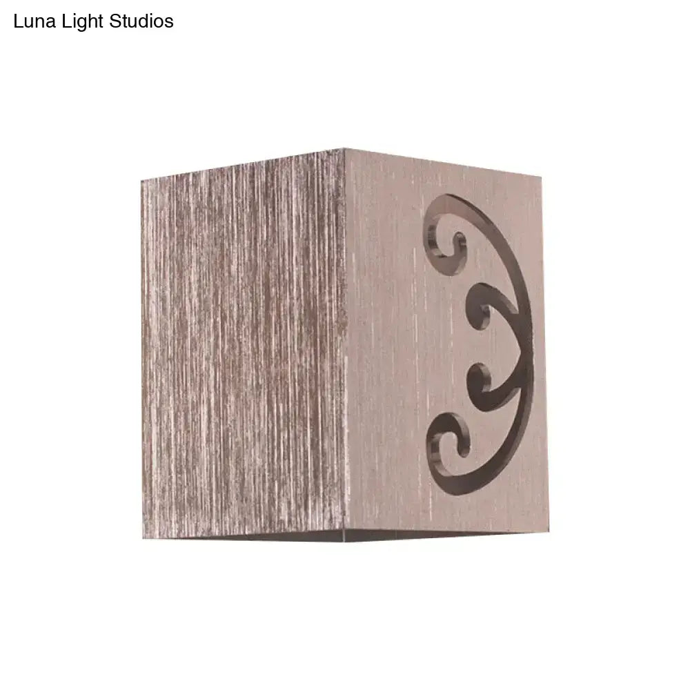 Modern black swirl led wall lamp featuring a brushed metallic cube with elegant scrollwork cutout for bedroom lighting