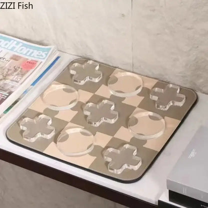 Modern black and tan acrylic chessboard set with clear cross and circle pieces on a beige and gray mat decorbites acrylic tic-tac-toe