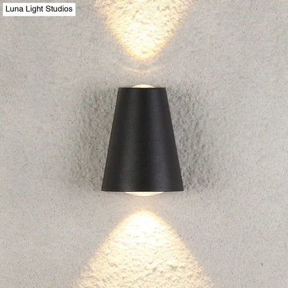 Modern black trapezoid wall light with sleek conical design casting warm light and maximum bulb wattage features