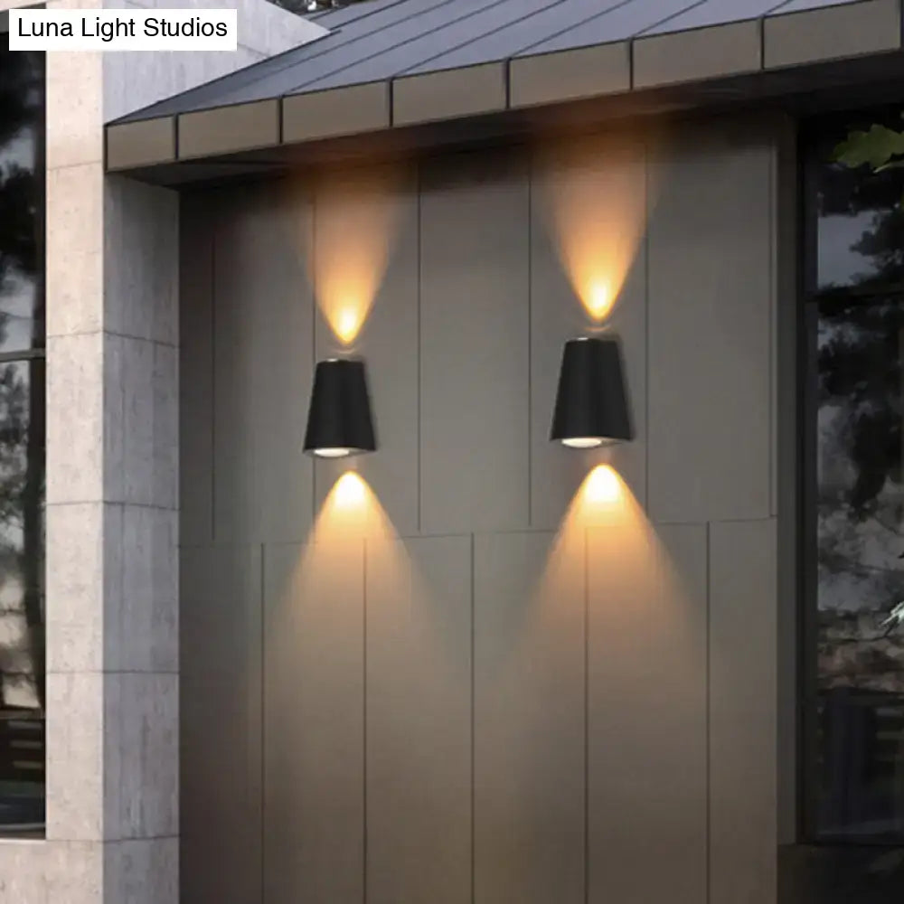 Modern black trapezoid wall light with maximum bulb wattage features conical outdoor sconces with warm focused lighting