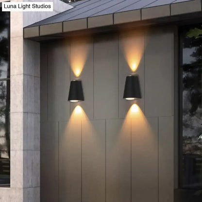Modern black trapezoid wall light with maximum bulb wattage features conical outdoor sconces with warm focused lighting