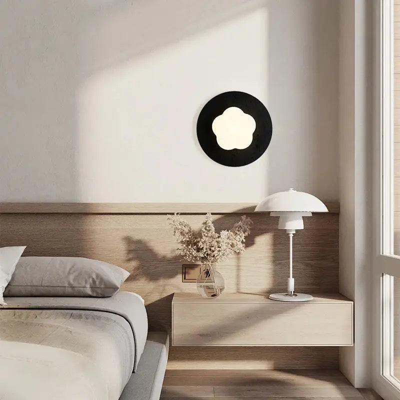 Modern black travertine flower LED wall lights with black circular wall sconce and white illuminated center for bedroom decor
