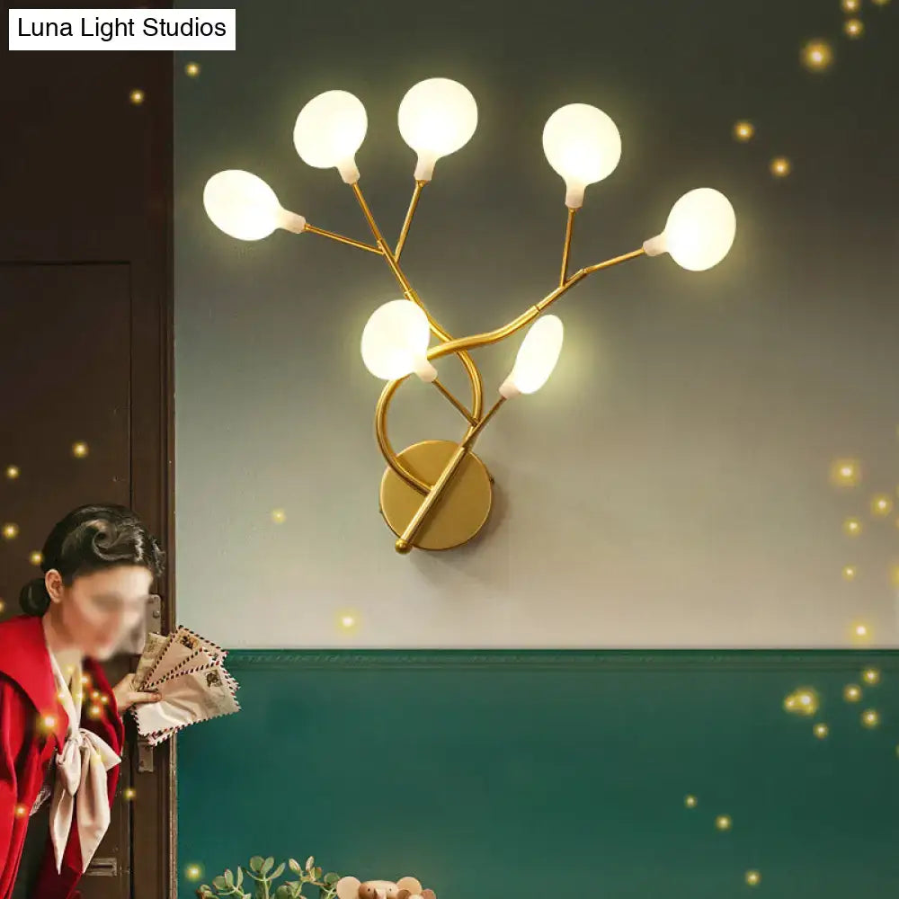 Gold-toned wall light with six frosted glass globes in a modern tree branch design 24 inch fixture for bedroom use
