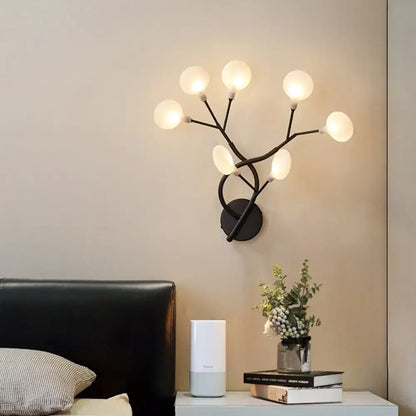 Modern black wrought iron wall light with six frosted glass globes in a tree branch design 24 inch fixture