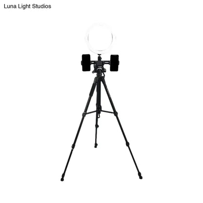 Modern black tripod with round shade ring light and two phone holders offers a stylish lighting solution for bedrooms