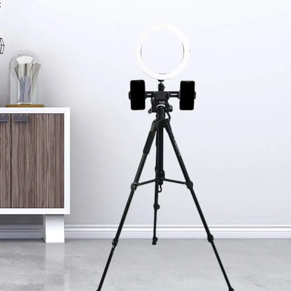 Modern black tripod with round shade ring light and two smartphones mounted as a stylish lighting solution for bedroom