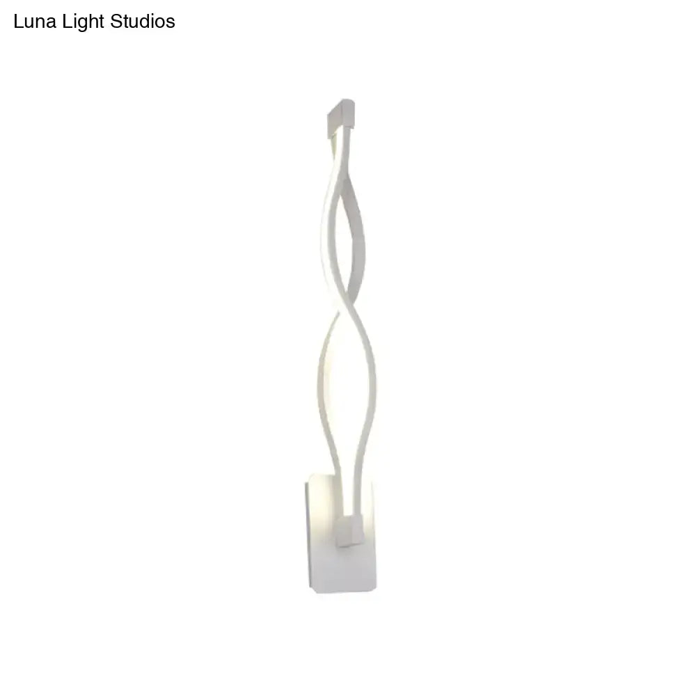 White led wall sconce with a sleek twisted design emitting warm white light for modern stairway or bedroom use
