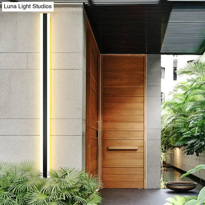 Modern black vertical led wall sconce ip65 waterproof beside a wooden front door with horizontal slats and minimalist design