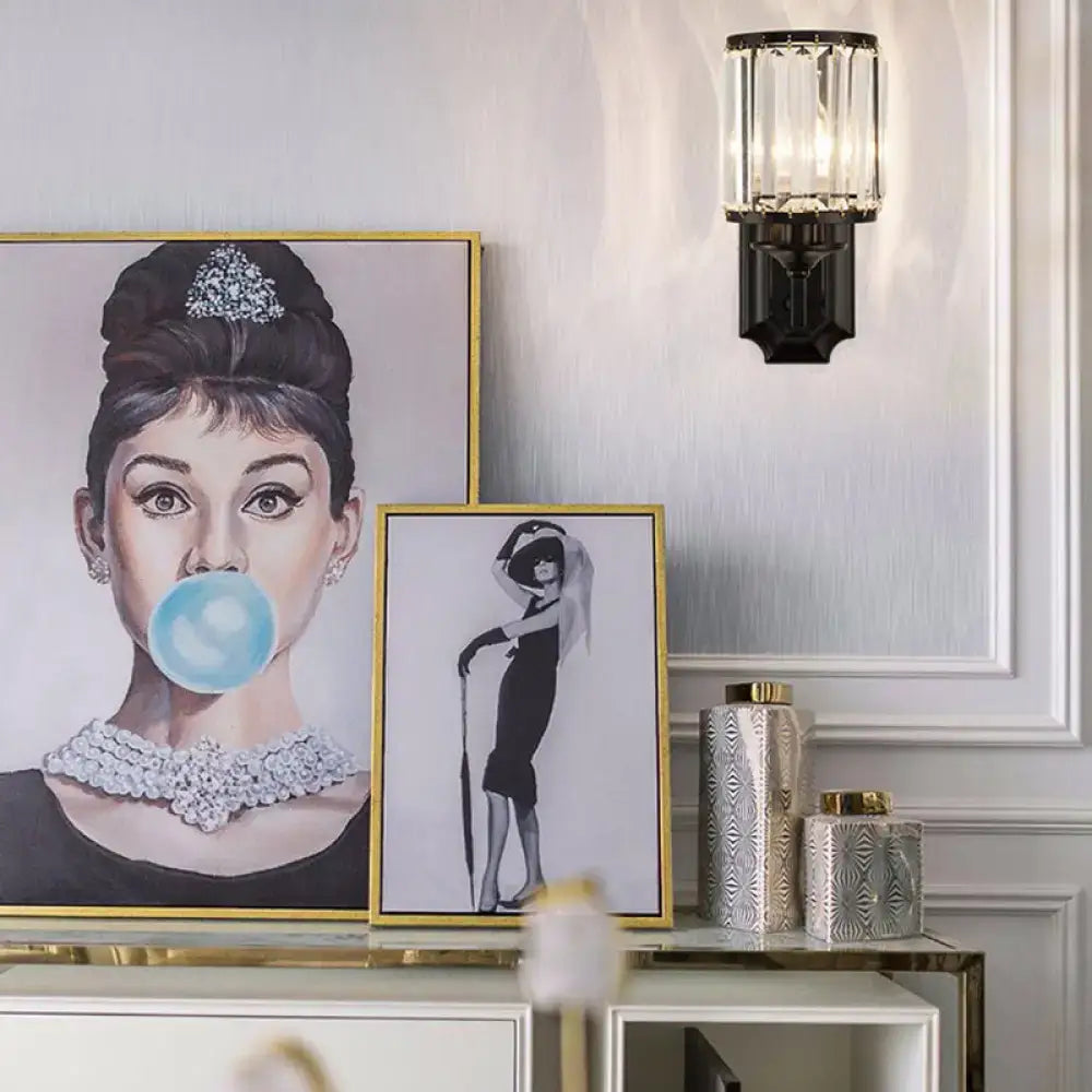 Modern black wall lamp with clear crystal prism features a framed audrey hepburn portrait in pastel tones with gold detailing