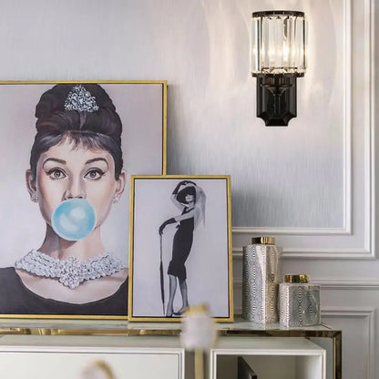 Modern black wall lamp with clear crystal prism features a framed audrey hepburn portrait in pastel tones with gold detailing