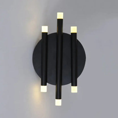 Modern black wall light with round backplate featuring three vertical led rods and white square light caps for bedroom use