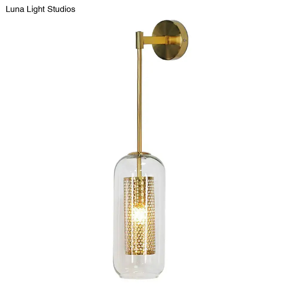 Gold-finished wall sconce with clear glass cylinder and intricate wire mesh honeycomb shade for modern lighting