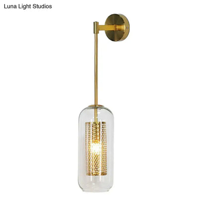 Gold-finished wall sconce with clear glass cylinder and intricate wire mesh honeycomb shade for modern lighting
