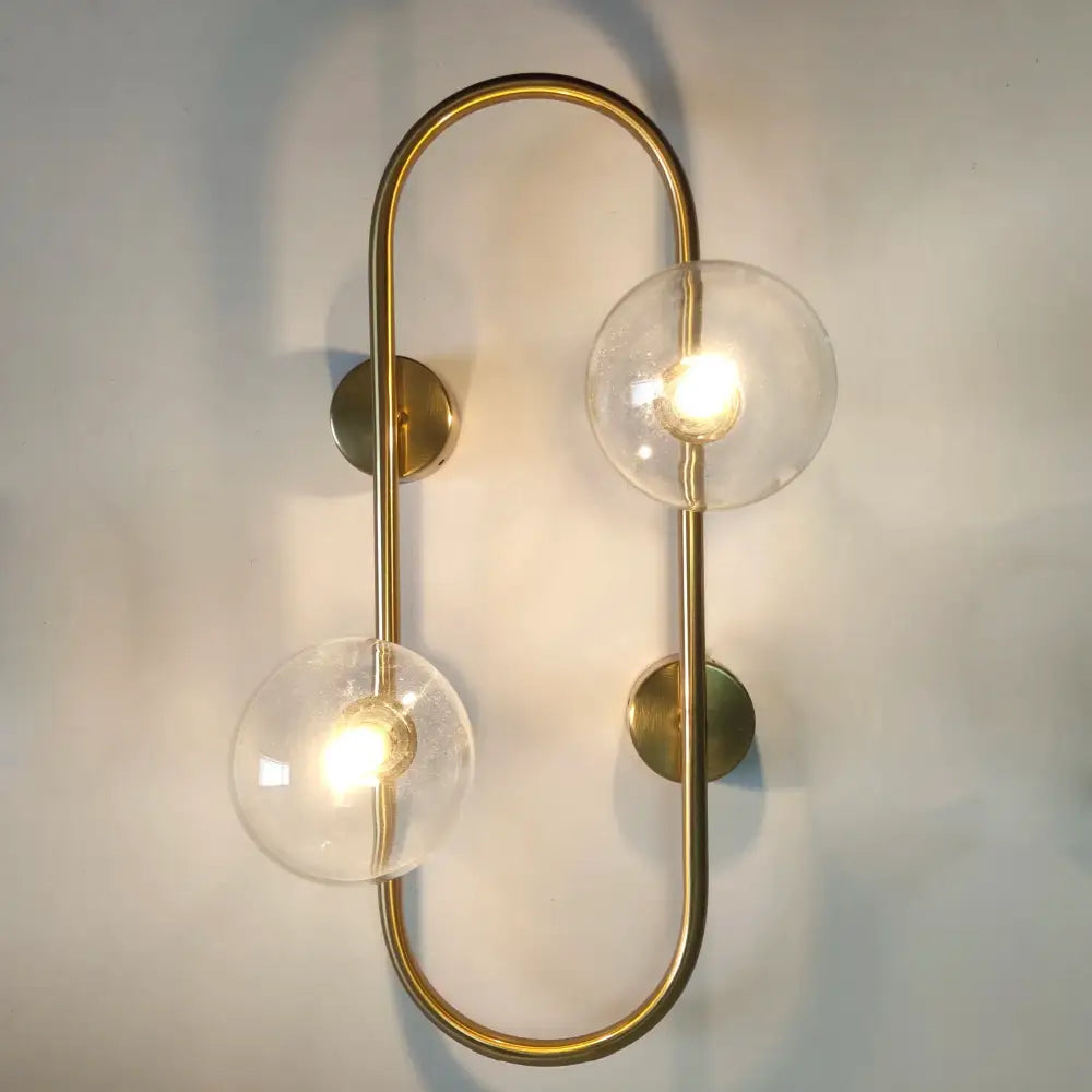 Modern brass led wall sconce with two clear glass globe shades ideal for bedroom decorbites brass led lighting