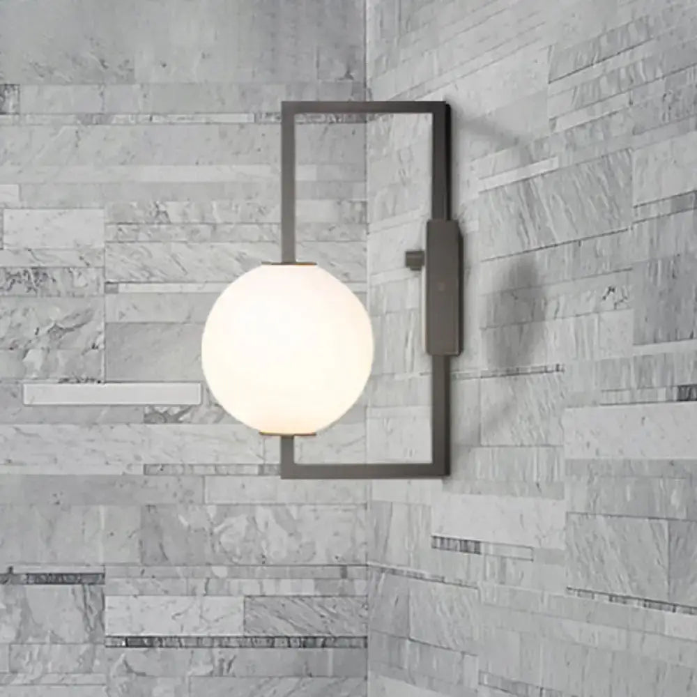 Modern black wall sconce with a frosted white glass orb shade ideal for bedroom lighting