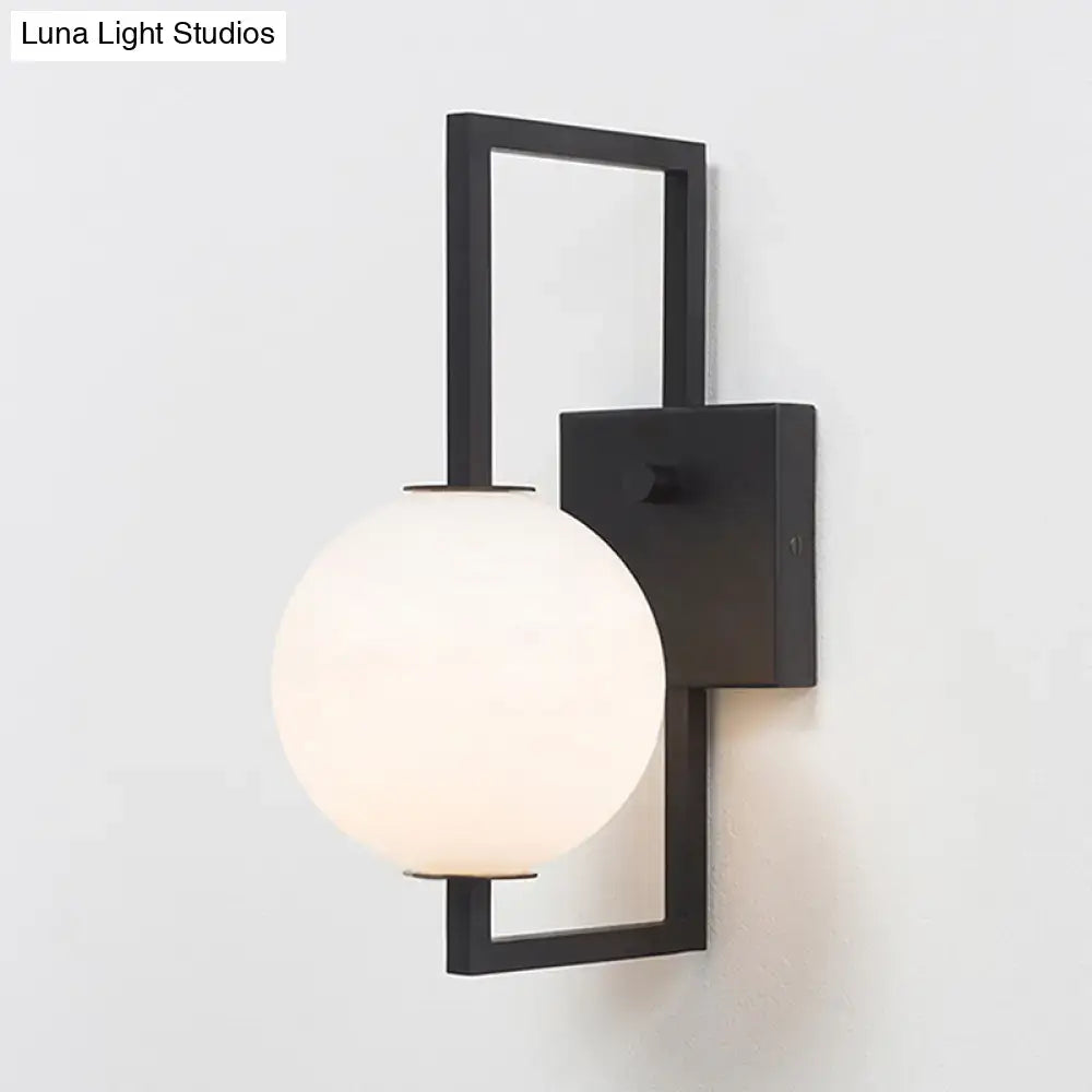 Modern black metal wall sconce with a frosted white glass orb shade for elegant bedroom lighting