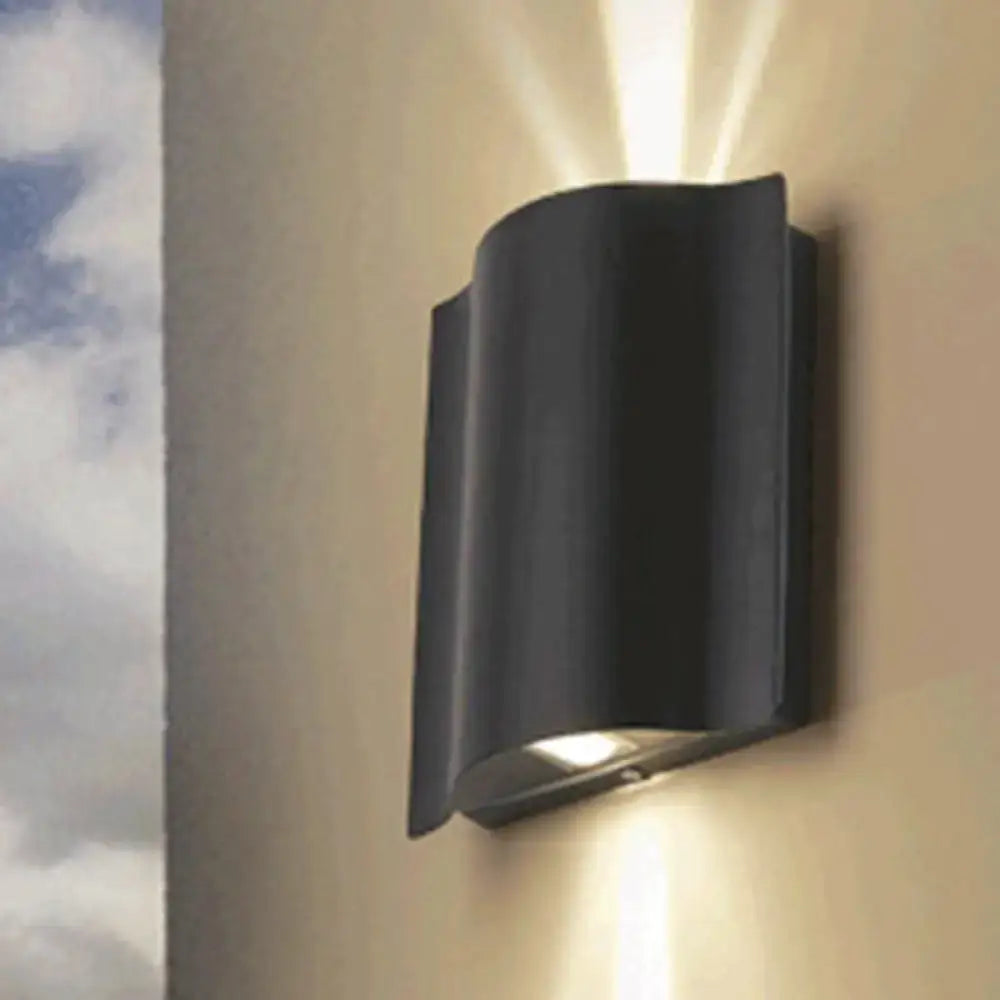 Modern black curved wall light with wavy metal shade and warm white light ideal for patio lighting