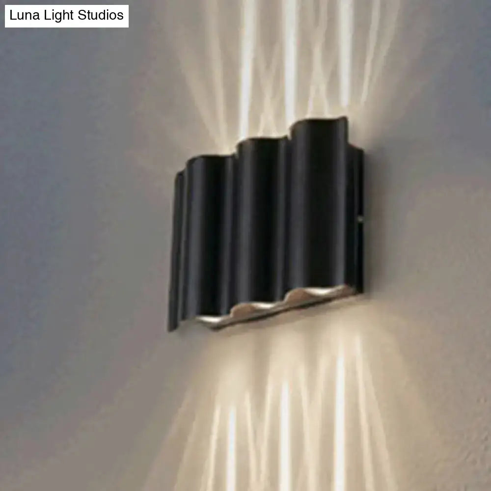 Modern black wavy metal shade wall light with warm white light beams for stylish patio illumination