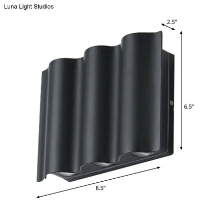 Modern black wavy metal shade wall light featuring a sleek outdoor design with warm white light for patios