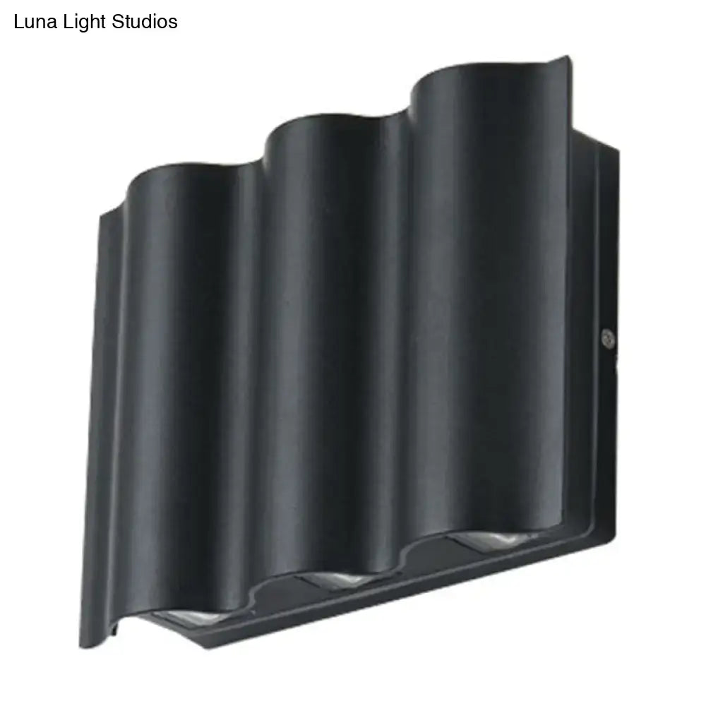 Black wavy metal shade wall light with sleek modern design emitting warm white light for patio use