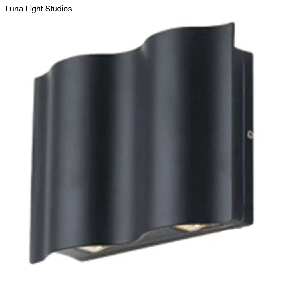 Modern black wavy metal shade wall light with sleek design providing warm white light for patio use