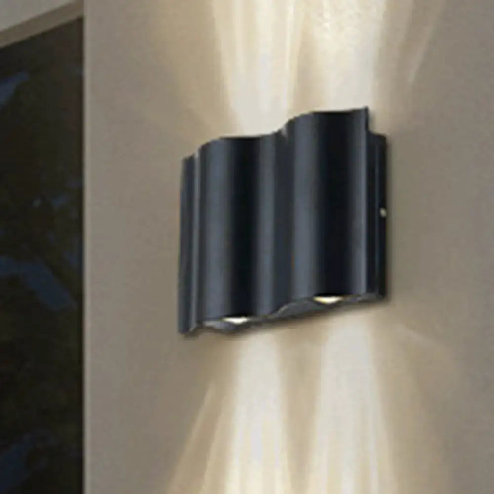 Modern black wavy metal shade wall light with sleek design providing warm white light for patio use