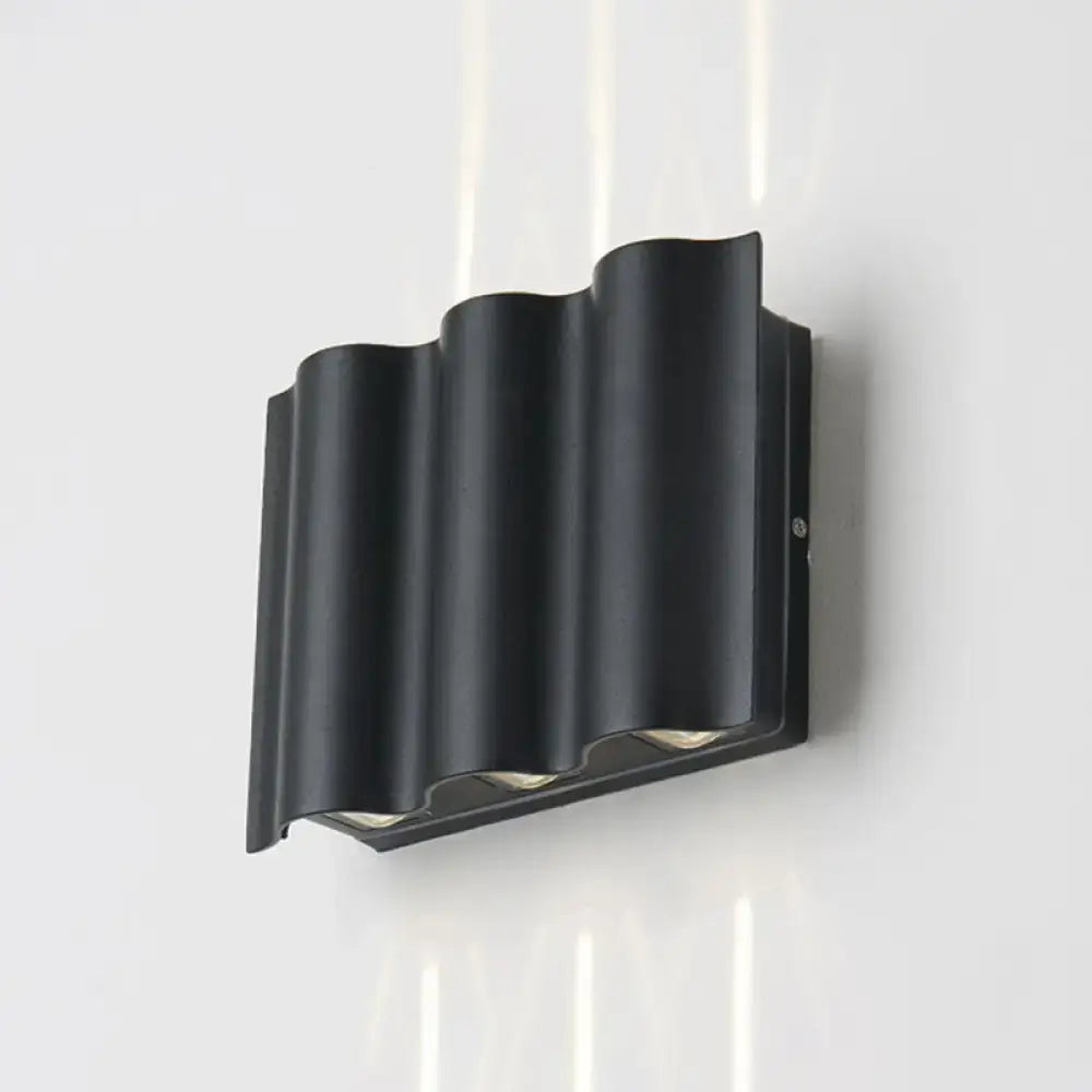 Modern black wavy metal shade wall light with warm white light and sleek design for patio use