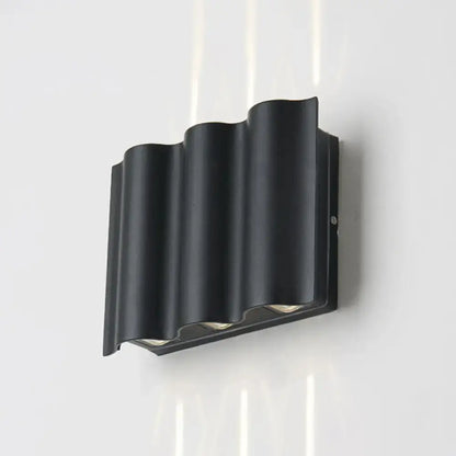Modern black wavy metal shade wall light with warm white light and sleek design for patio use