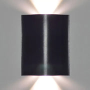 Modern black wavy wall washer lamp with sleek metallic finish and dual upward lights providing warm white lighting