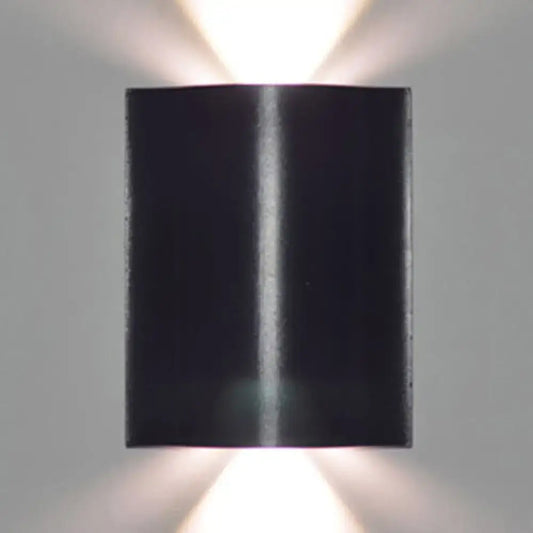 Modern black wavy wall washer lamp with sleek metallic finish and dual upward lights providing warm white lighting
