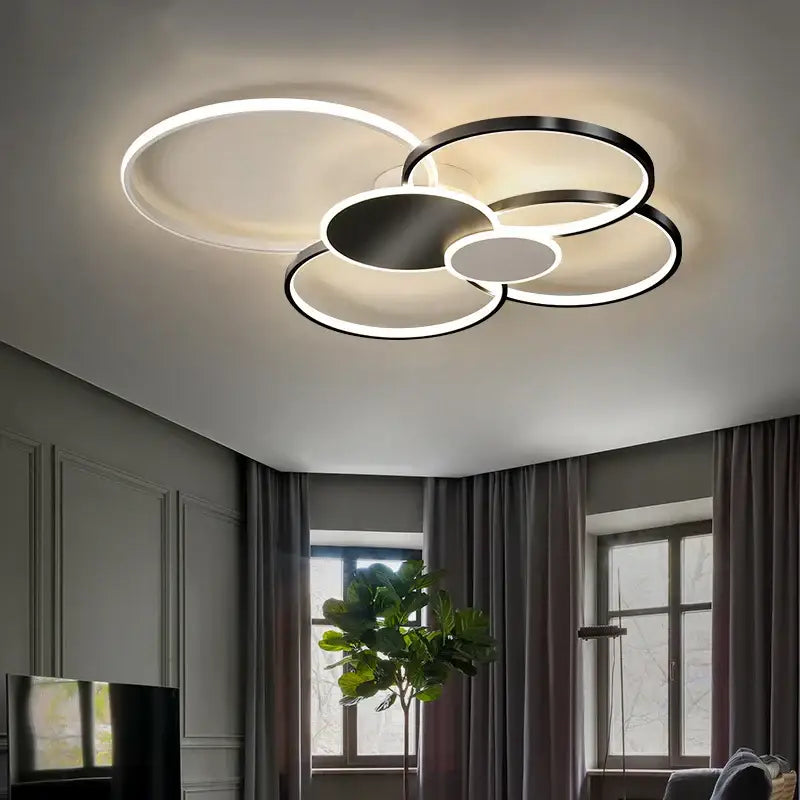 Modern black and white acrylic chandelier light with overlapping circular rings and sleek metallic finish for living room