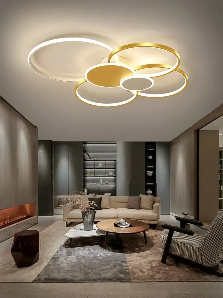 Modern black and white acrylic chandelier light featuring a gold and white circular led ceiling fixture with a cloud-like design