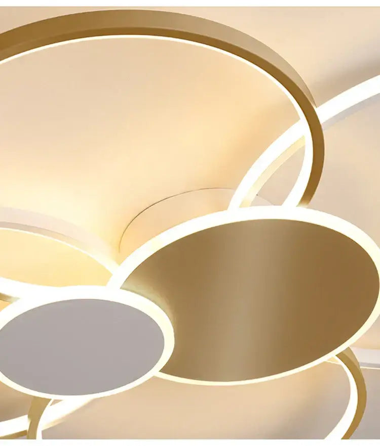Modern gold-toned circular led acrylic chandelier light with glowing edges and minimalist design for living room