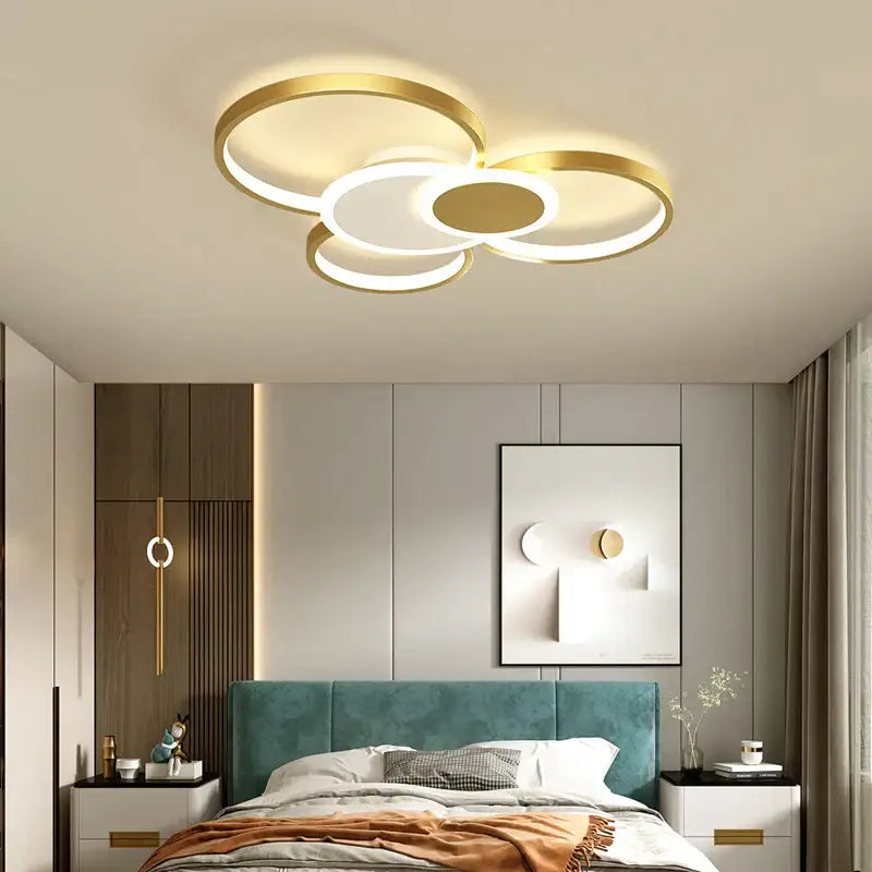 Modern black and white acrylic chandelier light with gold-toned interlocking rings and warm glow for living room