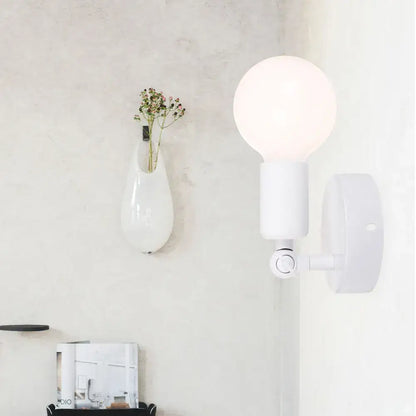 White spherical bulb mounted on a modern black and white adjustable wall lamp holder bedroom sconce with arm