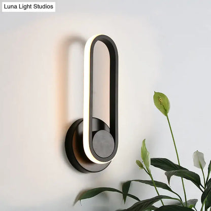 Modern black and white aluminum frame wall lamp with minimalist design emitting warm white light for bedroom use