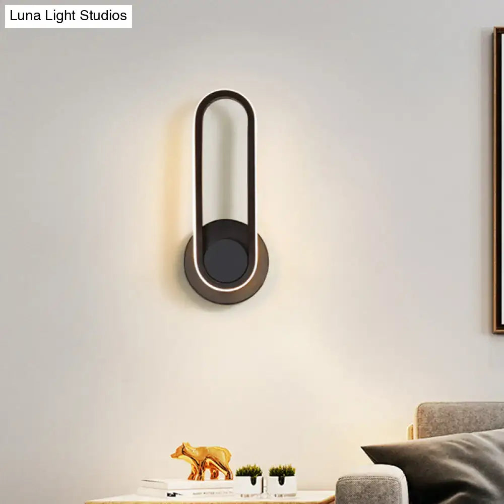 Modern black and white aluminum frame wall lamp with sleek oval design and warm white light for bedroom sconce