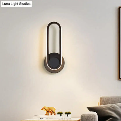 Modern black and white aluminum frame wall lamp with sleek oval design and warm white light for bedroom sconce
