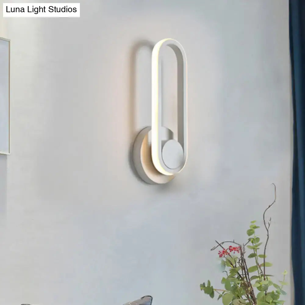 Modern black and white aluminum frame wall lamp with sleek oval design and layered accents emitting warm white light