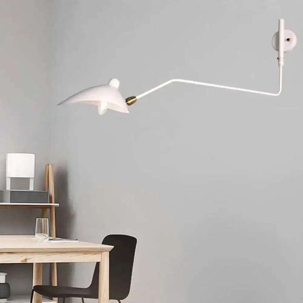 Modern black and white articulated wall sconce with brass joints mounted on white wall for living room light fixture