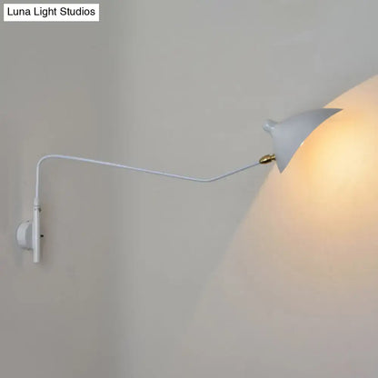 Modern black and white wall sconce with slender curved arm and brass accent light fixture for living room use
