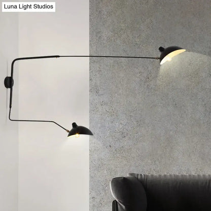 Black metal living room wall sconce with two articulated arms and dome-shaped shades light fixture