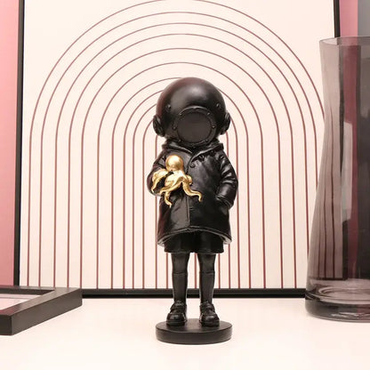 Modern black resin diver sculpture ornament of a child in vintage helmet holding a golden octopus for office decor